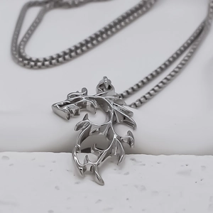 Macro shot of silver dragon pendant necklace featuring a polished square link chain