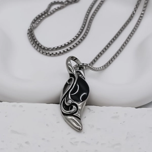 Dettaglio della collana con ciondolo a cono argento e incisioni totem in smalto nero