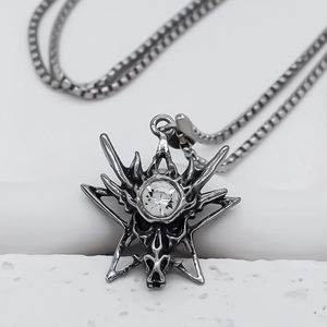 Détail du pendentif tête de dragon punk avec zircon blanc sur une chaîne à mailles