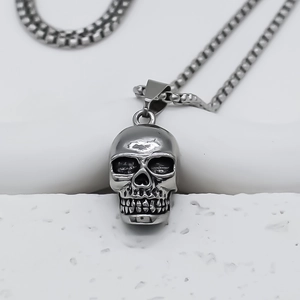 Détails d'un pendentif tête de mort argenté avec chaîne box et texture métal oxydé