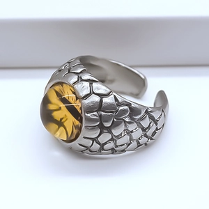 Macro shot of silver ring featuring dragon scale texture and amber dragon eye stone