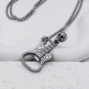 Détail du pendentif guitare argentée avec design de crâne et fonction décapsuleur intégré