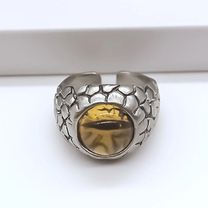 Macro shot of punk style dragon scale silver ring with amber cat eye gemstone inlay