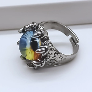 Macro view of adjustable dragon claw ring featuring a blue and yellow evil eye bead