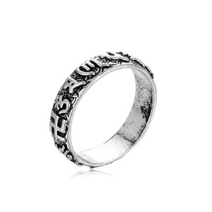 Macro view of antique silver ring featuring embossed vintage patterns and religious symbols