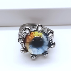 Macro shot of punk style dragon claw ring featuring a detailed realistic blue eyeball inlay