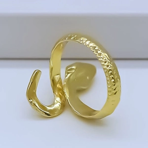 Detail of adjustable golden snake ring with hammered texture and vintage finish