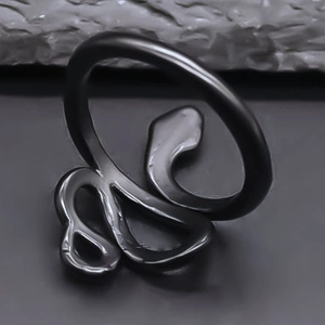 Detail view of a matte black snake-shaped ring in punk style on a dark background
