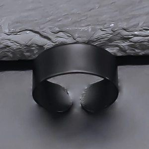 Minimalist matte black adjustable open ring for men and women on a dark stone background