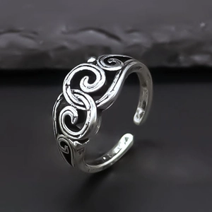 Macro shot of retro silver hollow carved ring with ornate swirl pattern detail