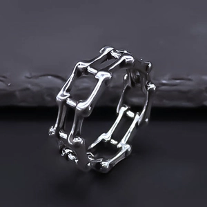 Macro shot of silver punk skeleton link ring showing intricate irregular hollow details