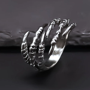 Silver vintage punk ring featuring a detailed dragon claw design on a dark stone background