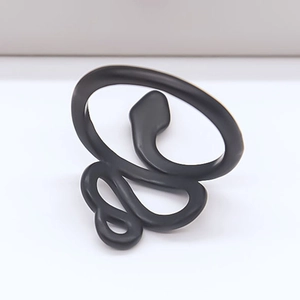Macro shot of matte black snake-shaped wrap ring with minimalist punk aesthetic