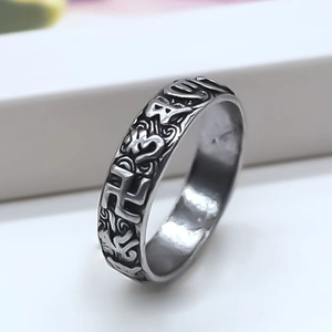 Macro detail of vintage silver ring with embossed religious patterns and aged finish
