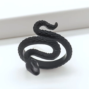 Macro shot of matte black snake ring showcasing detailed scales and gothic wrap design