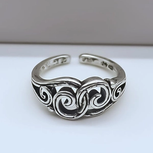 Macro shot of retro adjustable ring with scroll relief and blackened silver finish
