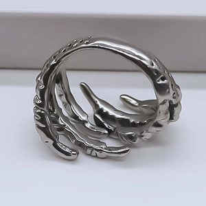 Macro shot of silver punk ring featuring detailed bio-claw texture and curved gothic design