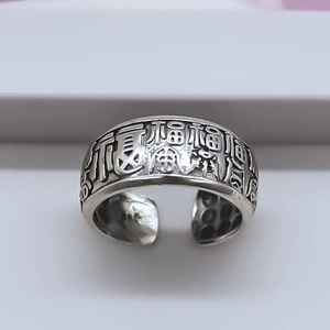 Close-up of vintage silver ring featuring embossed Chinese Fu characters and antique finish