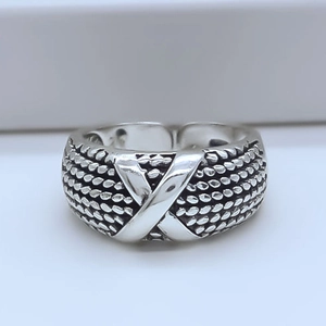 Close-up of vintage silver woven mesh ring featuring a smooth polished X-cross detail