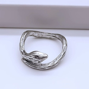Macro detail of silver snake ring featuring unique wood grain texture and open band design