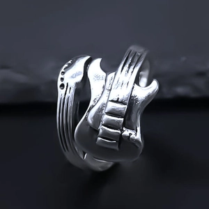 Macro detail of silver guitar ring showing fine strings and textured pickups on the body