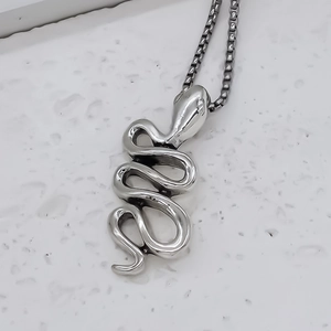 Détail du pendentif serpent argenté vintage avec des écailles réalistes et une chaîne maille