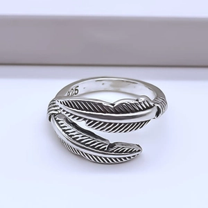 Macro detail of silver feather ring showing fine texture and 925 hallmark engraving