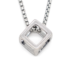 Dettaglio macro della collana con ciondolo a cubo geometrico in argento e catena box