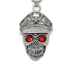 Close-up of punk style skull pendant with red gemstone eyes and silver alloy finish