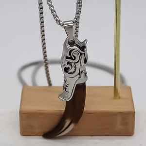 Vintage wolf tooth necklace with silver floral relief and brown resin pendant