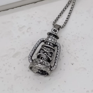 Gros plan sur pendentif lanterne crâne argenté vintage avec détails gothiques en métal