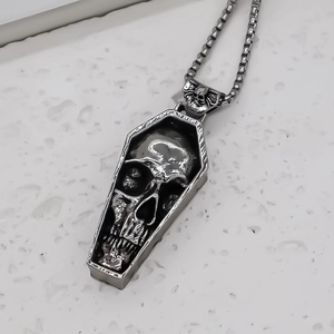 Gros plan du pendentif cercueil gothique avec relief tête de mort sur marbre gris