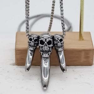 Gothic punk necklace featuring triple skull pendants and spikes on a steel box chain