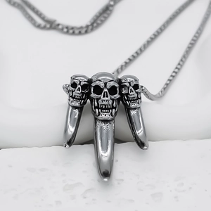 Gothic punk necklace featuring triple skull fang pendants in antique silver finish