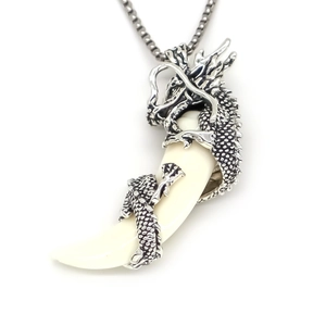 Gros plan détaillé du pendentif dragon argenté avec motif dent de loup couleur ivoire
