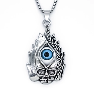 Macro shot of punk flame skull pendant featuring a deep blue demon eye on a steel chain