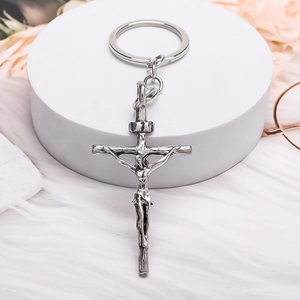 Vintage silver alloy crucifix cross keychain on a white decorative display stand