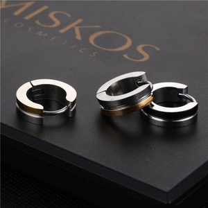 Two-tone stainless steel huggie earrings in silver gold and black finishes set on black box