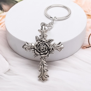 Retro silver cross keychain featuring a rose center and ornate floral engraving detail