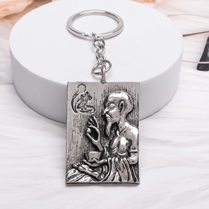 Vintage silver metal square keychain with embossed zen figure on a white pedestal