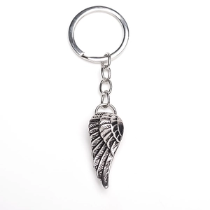 Detail of hip hop style silver wing pendant keychain with vintage feather textures