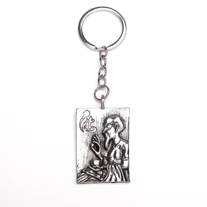 Close-up of antique silver rectangular keychain with embossed Zen figure and short chain