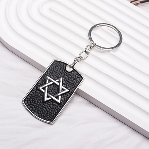 Detail of hip hop military dog tag keychain with textured black finish and silver hexagram