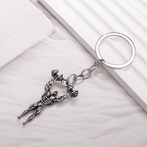 Antique silver fitness keychain featuring a muscular bodybuilder lifting a barbell weight