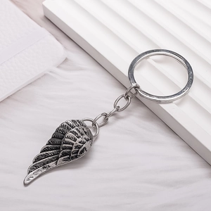 Vintage silver angel wing keychain with detailed feather texture and antique finish