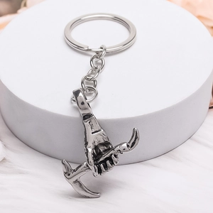 Portachiavi punk argento vintage con ciondolo a mano e piccone su superficie in pelliccia