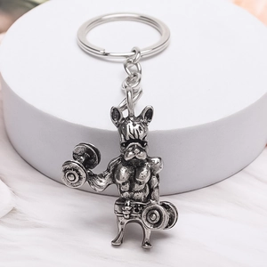 Porte-clés bouledogue français musclé argenté vintage avec haltères sur socle blanc