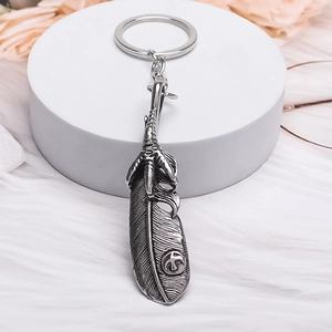 Vintage silver feather and eagle claw keychain with intricate retro ethnic texture