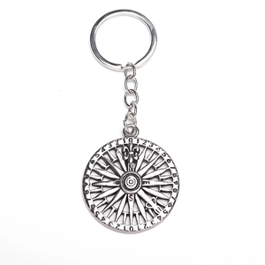 Macro view of vintage compass keychain with fleur-de-lis and numeric engravings