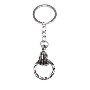 Retro gothic skull hand keychain with vintage silver finish on minimalist white background